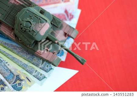 Bahraini dinar currency money bills and toy tank on flag. The concept of army funds and weapons Bahraini dinar currency money bills and toy tank on flag. The concept of army funds and weapons 143551283