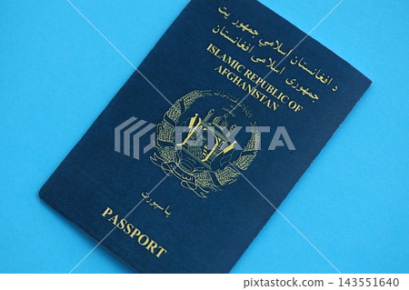 Afghan passport on table. Official identification document book for citizens of Afghanistan Afghan passport on table. Official identification document book for citizens of Afghanistan 143551640