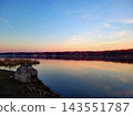 Calm River at Sunset With Warm Horizon Glow 143551787