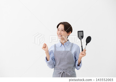 A cooking image of a woman holding a spatula and turner. 143552003