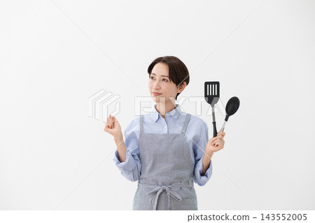 A cooking image of a woman holding a spatula and turner. A cooking image of a woman holding a spatula and turner. 143552005