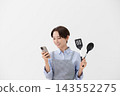 An image of a woman checking a recipe on her smartphone. 143552275