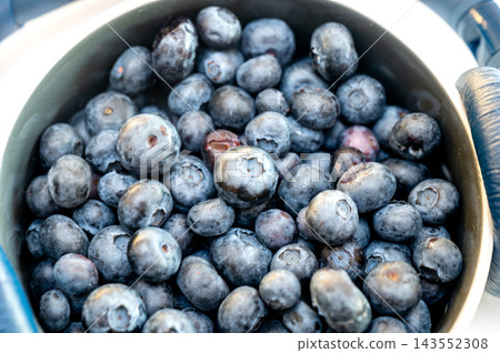 Fresh Blueberries and Headphones Concept. A close up of fresh blueberries in a bowl with headphones, a conceptual image of summer fruit and technology, a creative and healthy idea of the sound of summ Fresh Blueberries and Headphones Concept. A close up of fresh blueberries in a bowl with headphones, a conceptual image of summer fruit and technology, a creative and healthy idea of the sound of summ 143552308