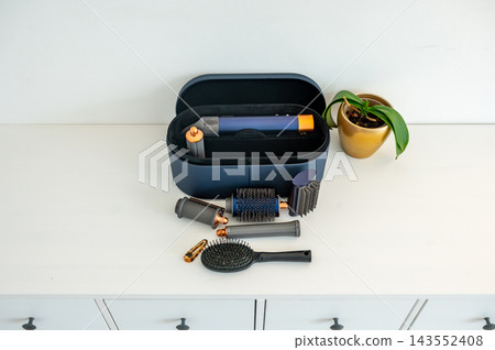 Hair clip and brushes beside open case morning styling scene. Tortoise hair clip and professional brushes beside open styling case in morning light, getting ready scene for beauty routine and feminine Hair clip and brushes beside open case morning styling scene. Tortoise hair clip and professional brushes beside open styling case in morning light, getting ready scene for beauty routine and feminine 143552408