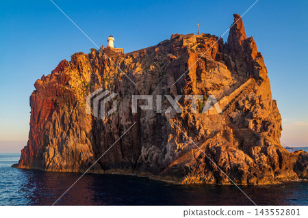 Scenic view of the volcanic island Strombolicchio with a historic white lighthouse rising from the blue Tyrrhenian sea, Aeolian archipelago, Sicily, Italy Scenic view of the volcanic island Strombolicchio with a historic white lighthouse rising from the blue Tyrrhenian sea, Aeolian archipelago, Sicily, Italy 143552801