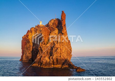 Scenic view of the volcanic island Strombolicchio with a historic white lighthouse rising from the blue Tyrrhenian sea, Aeolian archipelago, Sicily, Italy Scenic view of the volcanic island Strombolicchio with a historic white lighthouse rising from the blue Tyrrhenian sea, Aeolian archipelago, Sicily, Italy 143552802