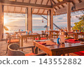 Elegant beach restaurant tables glowing sunset ocean view terrace calm tropical resort dining ambience. Romantic honeymoon dinner escape. Intimate exclusive hospitality 143552882