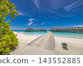 Wooden jetty leading overwater villas vivid turquoise Maldives lagoon lush palms blue sky bright. Digital nomad remote workation. Dream escape freelance lifestyle 143552885