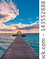 Overwater bungalow calm vivid turquoise Maldives lagoon pastel sky soft clouds bright tropical resort. Wellness meditation calm retreat. Peaceful serene restorative escape 143552888
