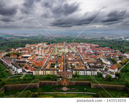Neuf-Brisach moody aerial dramatic sky over star citadel. Neuf-Brisach star citadel under dramatic overcast sky, moody aerial view with atmospheric dark clouds over Vauban fortress and green ramparts Neuf-Brisach moody aerial dramatic sky over star citadel. Neuf-Brisach star citadel under dramatic overcast sky, moody aerial view with atmospheric dark clouds over Vauban fortress and green ramparts 143553059