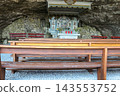 Interior view of the historic Wildkirchli cave chapel with wooden benches and stone altar inside a mountain cave in the Alpstein region, Switzerland 143553752