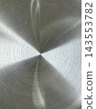 Brushed metal surface with concentric circular grooves radiating from center point and light reflections forming bright and dark sectors 143553782