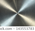 Brushed metal surface with circular grain and four bright light rays meeting at a central point, X-shaped reflection pattern 143553783