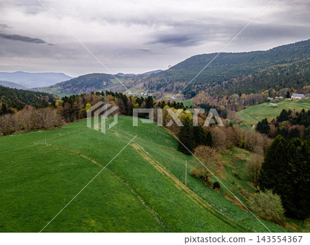 Rolling green hill with winding path and mountain overlook. Rolling green hill with winding hiking path leading to tranquil mountain overlook, aerial view of spring meadow trail with distant peaks on Rolling green hill with winding path and mountain overlook. Rolling green hill with winding hiking path leading to tranquil mountain overlook, aerial view of spring meadow trail with distant peaks on 143554367