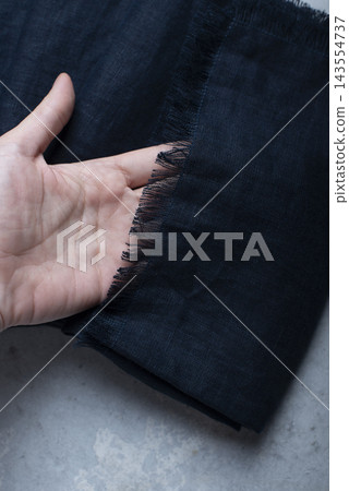 Hand Holding Fringed Edge Dark Navy Blue Linen Tablecloth Hand Holding Fringed Edge Dark Navy Blue Linen Tablecloth 143554737