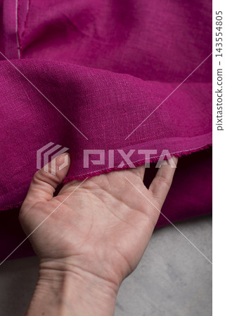 Hand Holding Raw Edge Fuchsia Pink Linen Fabric Hand Holding Raw Edge Fuchsia Pink Linen Fabric 143554805