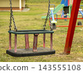 Empty Worn Toddler Swing Seat Hanging In Outdoor Playground On A Sunny Day 143555108