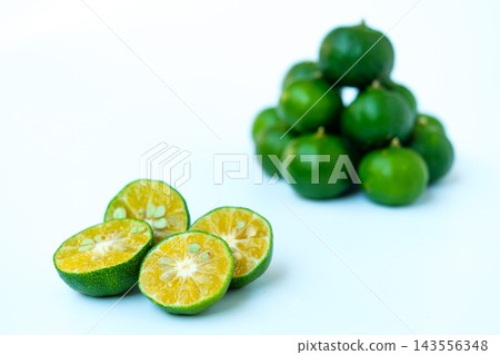 Half a slice of shikwasa fruit, with the focus on the foreground. Half a slice of shikwasa fruit, with the focus on the foreground. 143556348