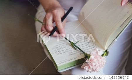 Open journal with a pink carnation and pen. Thoughts, memories and romantic notes. Open journal with a pink carnation and pen. Thoughts, memories and romantic notes. 143556942