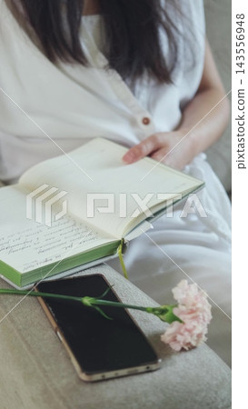 Notebook, phone and carnation on a sofa, top view. Balance between digital and real life. 143556948