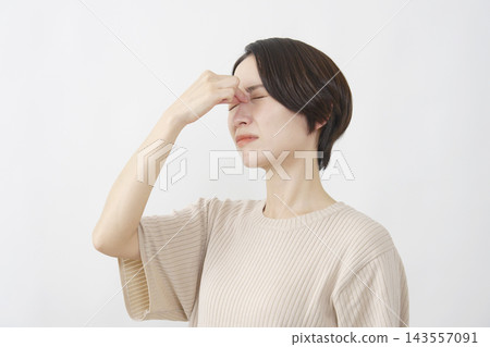 一位四十多歲的女性利用白色背景來舒緩疲憊的雙眼。 143557091