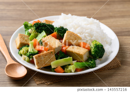 Stir fried tofu, broccoli and carrot with cooked rice Stir fried tofu, broccoli and carrot with cooked rice 143557216