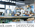 A factory scene. Factory, workshop, small factory, small business, table, line, production, tools, assembly, manufacturing industry, work, workshop. 143557256