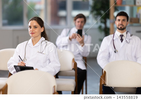 Medical students or doctors attending training session in modern lecture room Medical students or doctors attending training session in modern lecture room 143558819