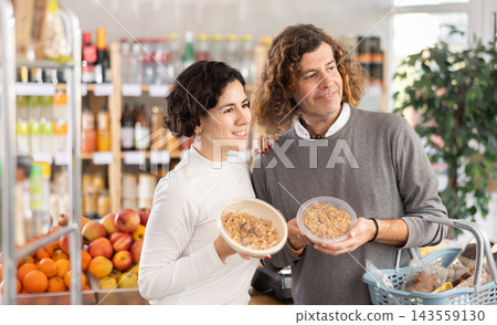 Family chooses yakisoba - Japanese cuisine dish, while shopping in supermarket Family chooses yakisoba - Japanese cuisine dish, while shopping in supermarket 143559130