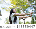 Asian Woman Stretching Arms Forward with Closed Eyes in Nature 143559447