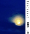 月亮懸掛在深藍色的夜空中，薄薄的雲層被它的光芒照亮。 143560651
