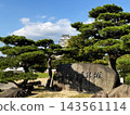 The keep of Himeji Castle, a World Heritage Site and National Treasure, stands out against the blue sky. 143561114