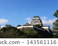The keep of Himeji Castle, a World Heritage Site and National Treasure, stands out against the blue sky. 143561116