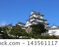 The keep of Himeji Castle, a World Heritage Site and National Treasure, stands out against the blue sky. 143561117