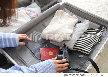 一位女士正在收拾行李準備旅行 一位女士正在收拾行李準備旅行 143561378
