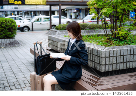 一位女士在長椅上使用筆記型電腦。 143561435