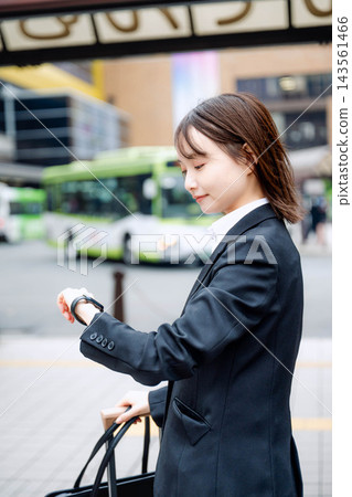 一位女商人正在火車站看手錶。 一位女商人正在火車站看手錶。 143561466