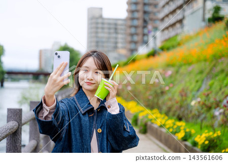 聽到在智能手機的音樂的婦女 聽到在智能手機的音樂的婦女 143561606