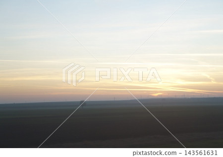 夕陽西下,霧氣繚繞的草原籠罩在光暈之中。 夕陽西下,霧氣繚繞的草原籠罩在光暈之中。 143561631