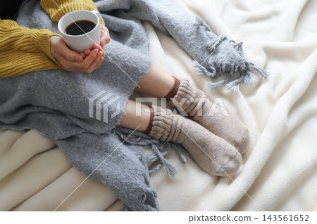 一位女士正捧著一杯熱咖啡取暖。 一位女士正捧著一杯熱咖啡取暖。 143561652