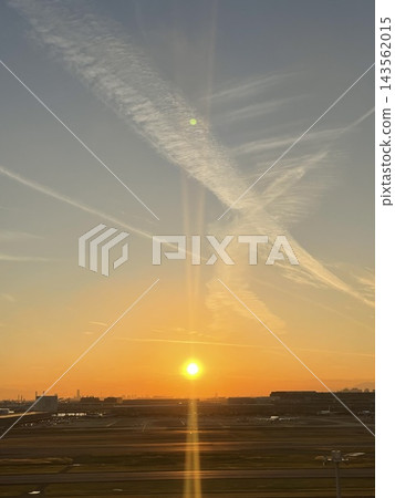 機場在夕陽的映照下，飛機尾跡交錯縱橫。 143562015