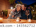 Loving senior couple enjoying romantic evening together on terrace. 143562712