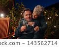 Loving senior couple enjoying romantic evening together on terrace. 143562714