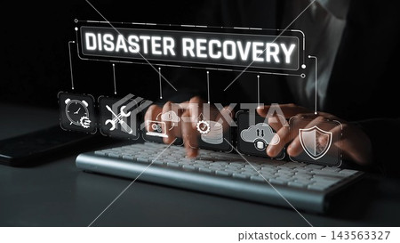 An engaged professional focuses on disaster recovery solutions through technology, featuring keyboard work and various icons symbolizing data protection and innovation. Sigmoid An engaged professional focuses on disaster recovery solutions through technology, featuring keyboard work and various icons symbolizing data protection and innovation. Sigmoid 143563327
