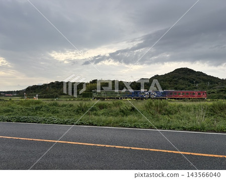 色彩繽紛的當地火車穿梭於鬱鬱蔥蔥的山村和鄉村風光之間 色彩繽紛的當地火車穿梭於鬱鬱蔥蔥的山村和鄉村風光之間 143566040