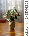 White Lily Flowers in Vase on Wooden Table 143566305