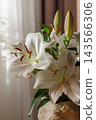 White Lily Flowers in Vase on Wooden Table 143566306