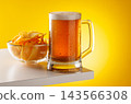 Beer mug with foam and chips on yellow background snack setup 143566308