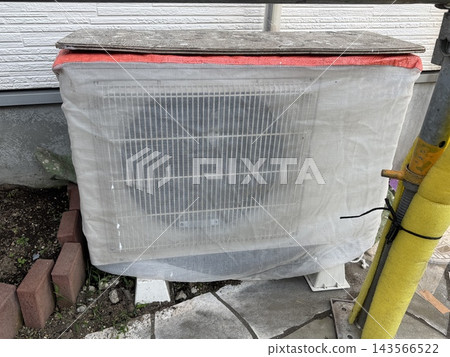 Air conditioner outdoor unit covered for protection during exterior wall painting work. Air conditioner outdoor unit covered for protection during exterior wall painting work. 143566522