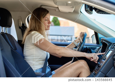 Woman pressing start button to start car Woman pressing start button to start car 143566645